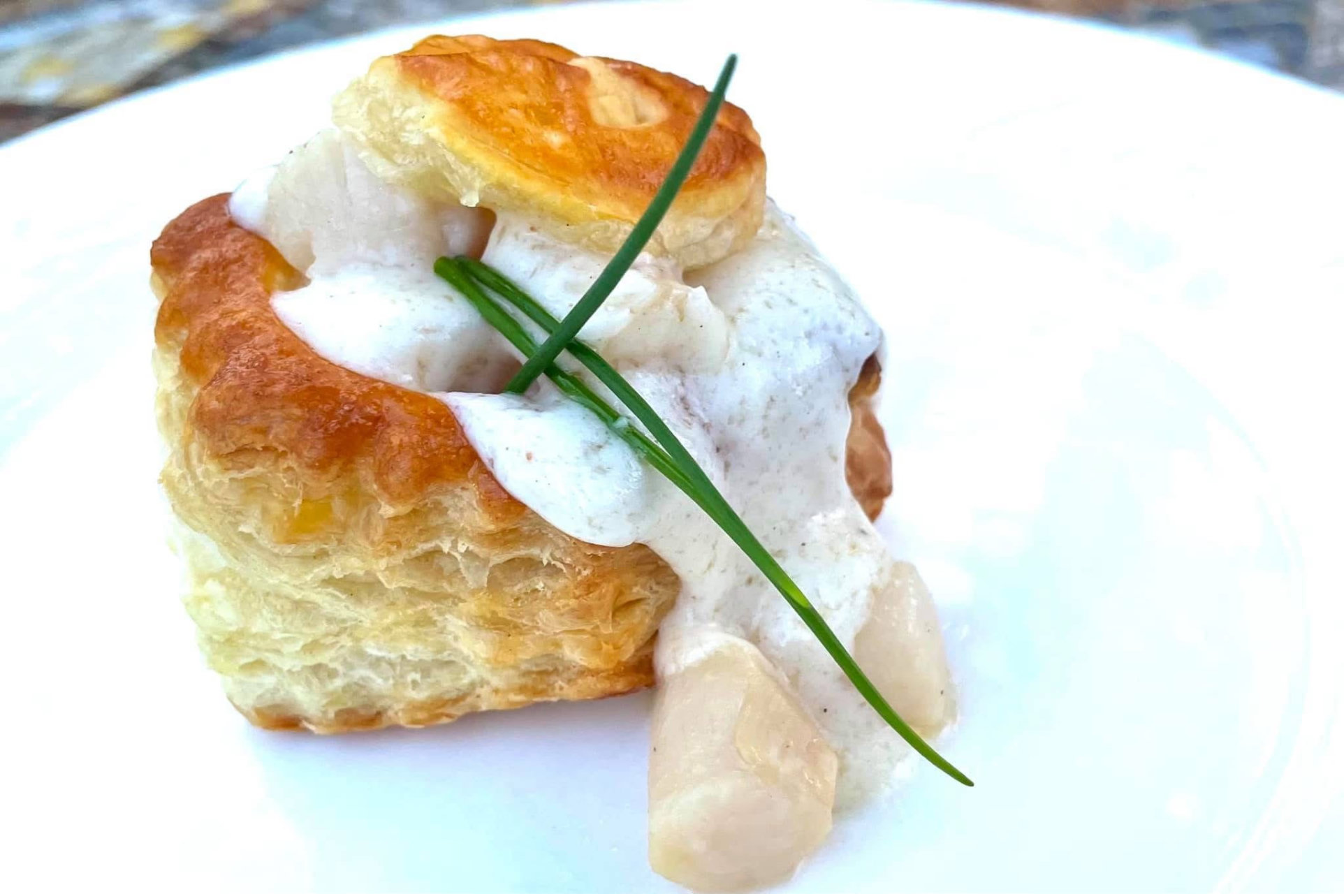 Savory puff pastry entree with chive garnish